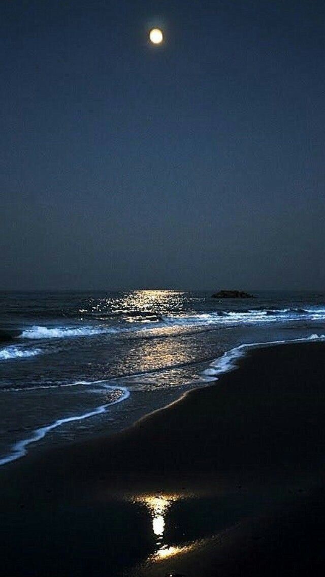 the moon shines brightly in the dark night sky over the ocean with waves crashing on it