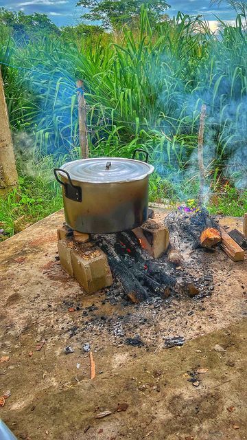 a pot is cooking over an open fire