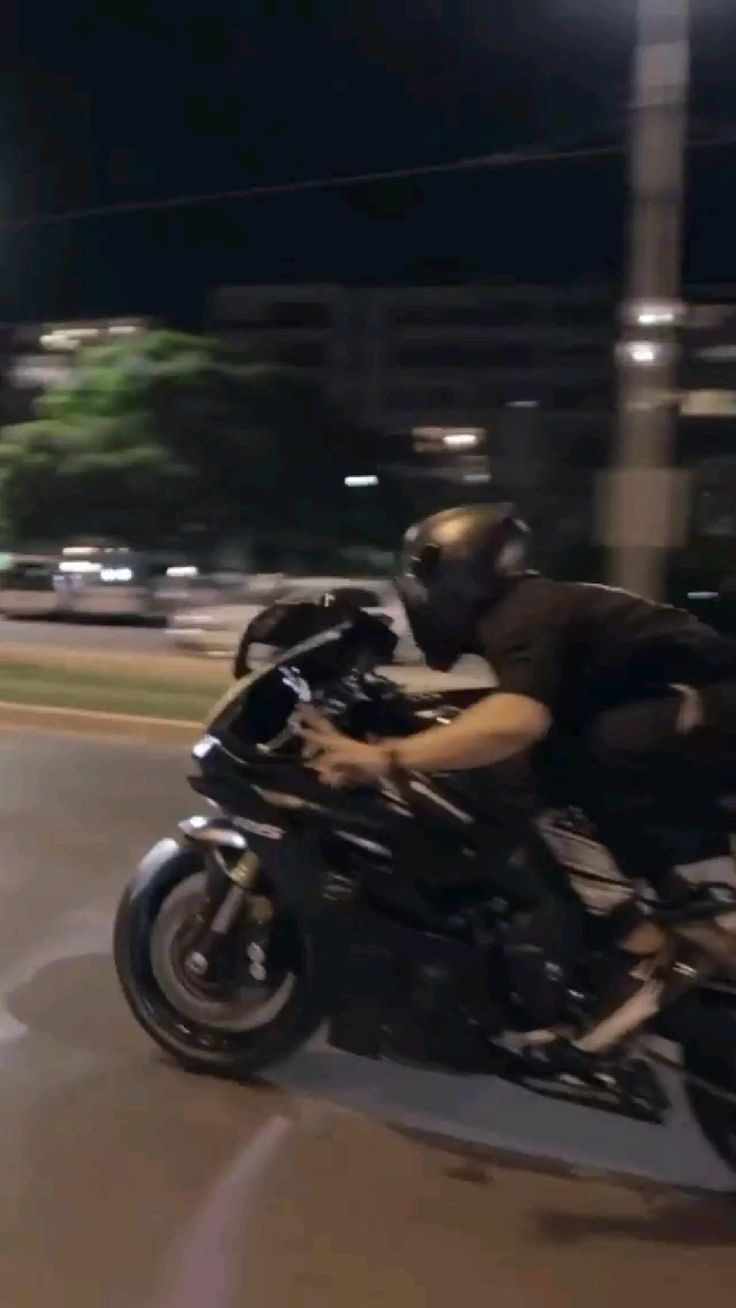 a man riding on the back of a black motorcycle