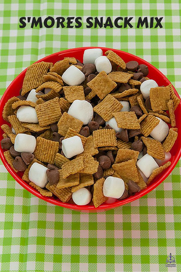 a red bowl filled with marshmallows and chocolate chips on top of a checkered table cloth