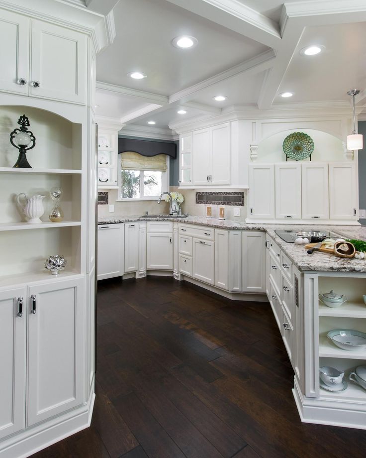 a large kitchen with white cabinets and wood flooring is pictured in this image from the inside