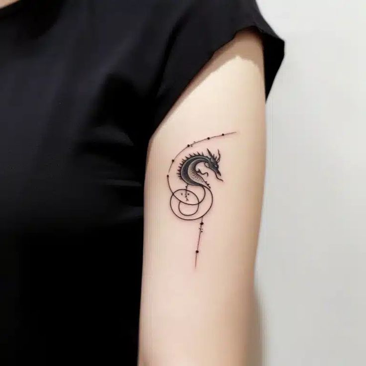 a woman's arm with a dragon tattoo on the left side of her arm