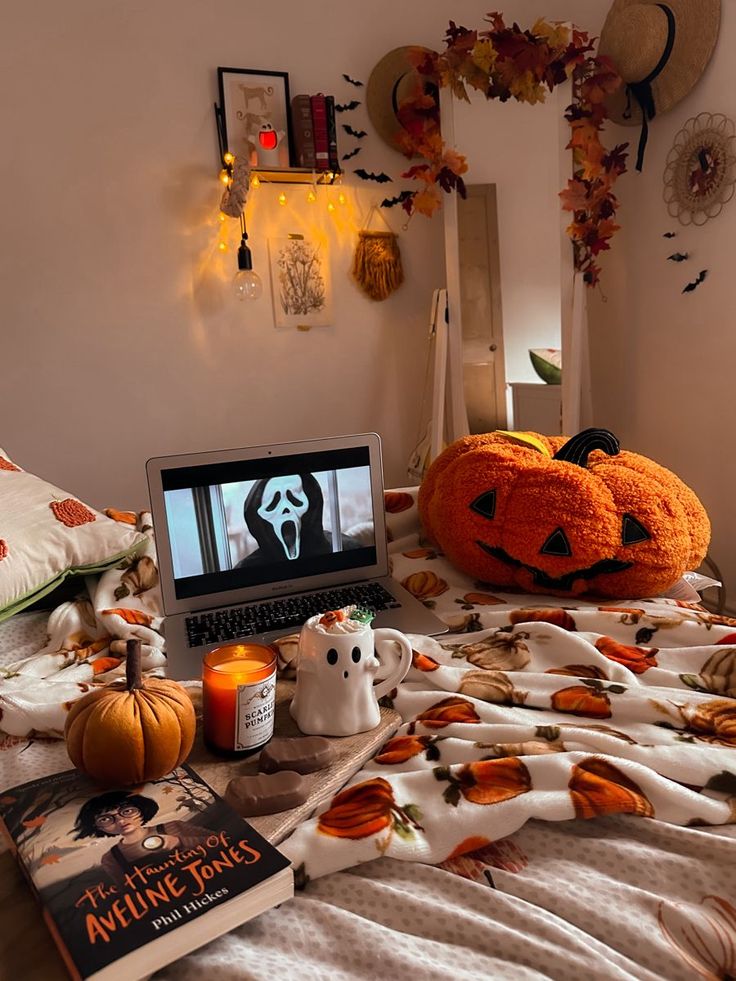 a laptop computer sitting on top of a bed covered in pumpkins and other decorations