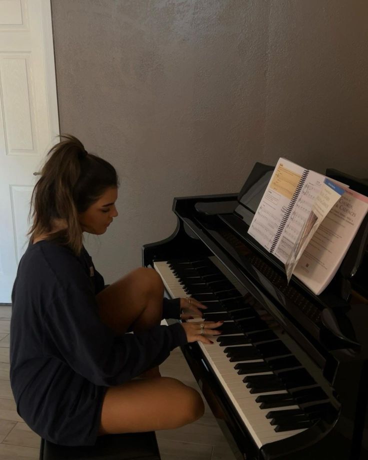 a young woman sitting at a piano playing music