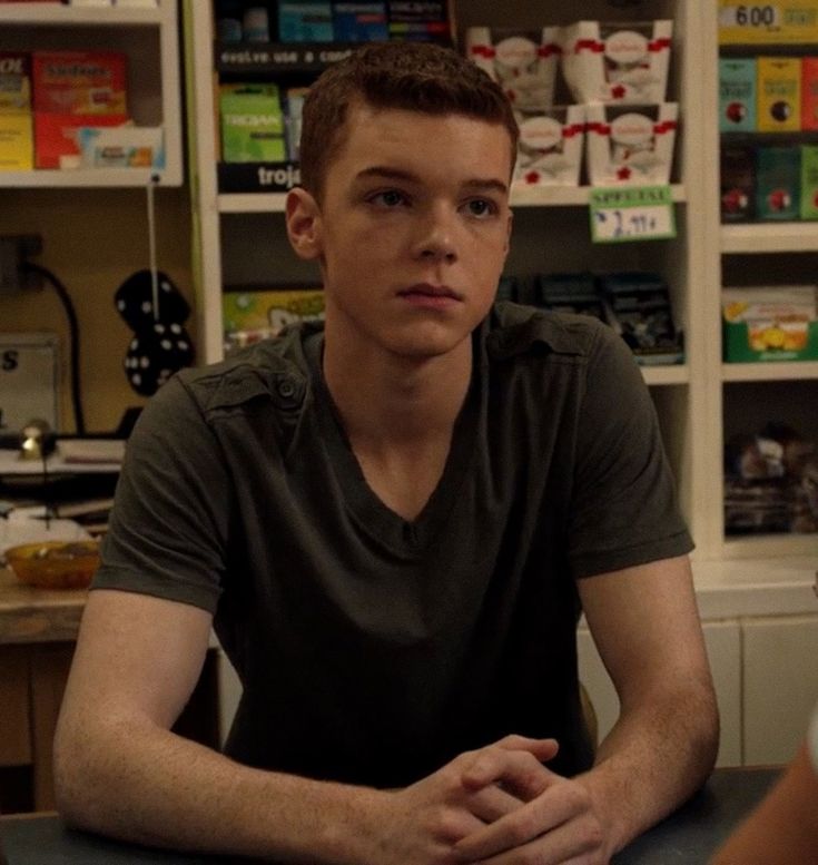 a young man sitting at a table in a store