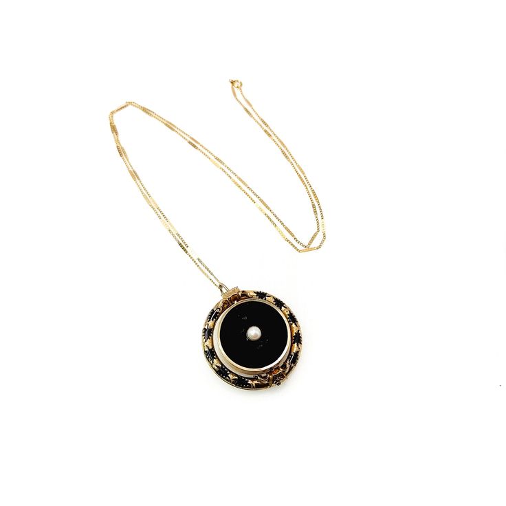 "Designed to commemorate a lost loved one, this historic flip fob pendant is accented with a 5mm seed pearl set into the yellow gold-filled metal. The metal is decorated with black enamel in mid-Victorian designs. The back compartment is filled with dark brown fabric and could hold a small keepsake. Dripping in Victorian elegance, this would make a wonderful addition to your antique collection. The necklace is in good antique condition with some signs of wear. The black background of the front h Victorian Locket Pendant Necklace, Victorian Style Locket Pendant Necklaces, Victorian Pendant Locket Necklace, Heirloom Pendant Necklaces With Lobster Clasp, Heirloom Pendant Necklace With Lobster Clasp, Victorian Necklaces With Detachable Pendant, Vintage Black Locket Necklace Gift, Victorian Black Enamel Necklace For Gift, Victorian Necklace With Detachable Pendant