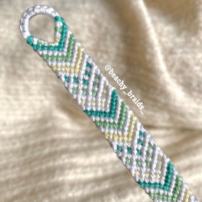 the beaded bracelet is made with white and green seed beads, which are attached to a silver clasp