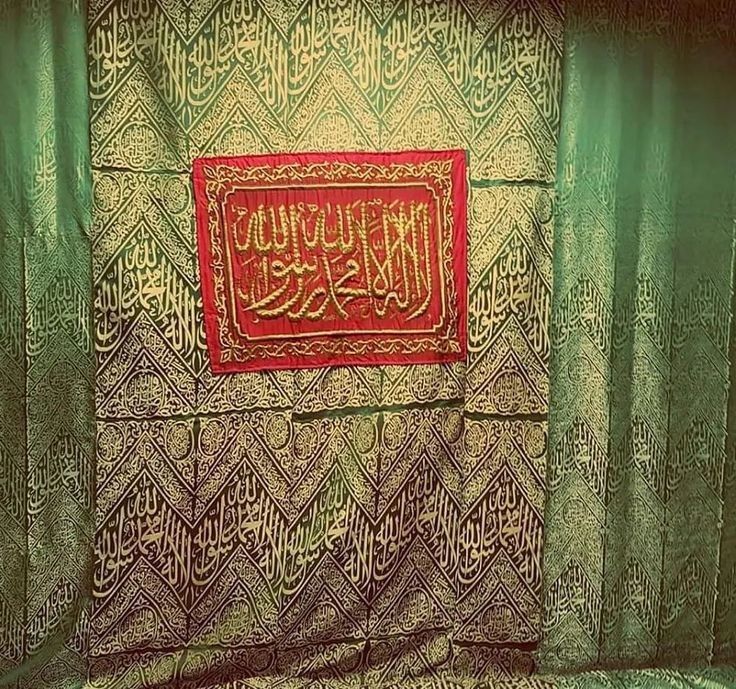 an arabic calligraphy is displayed on a green curtained room with red and gold accents