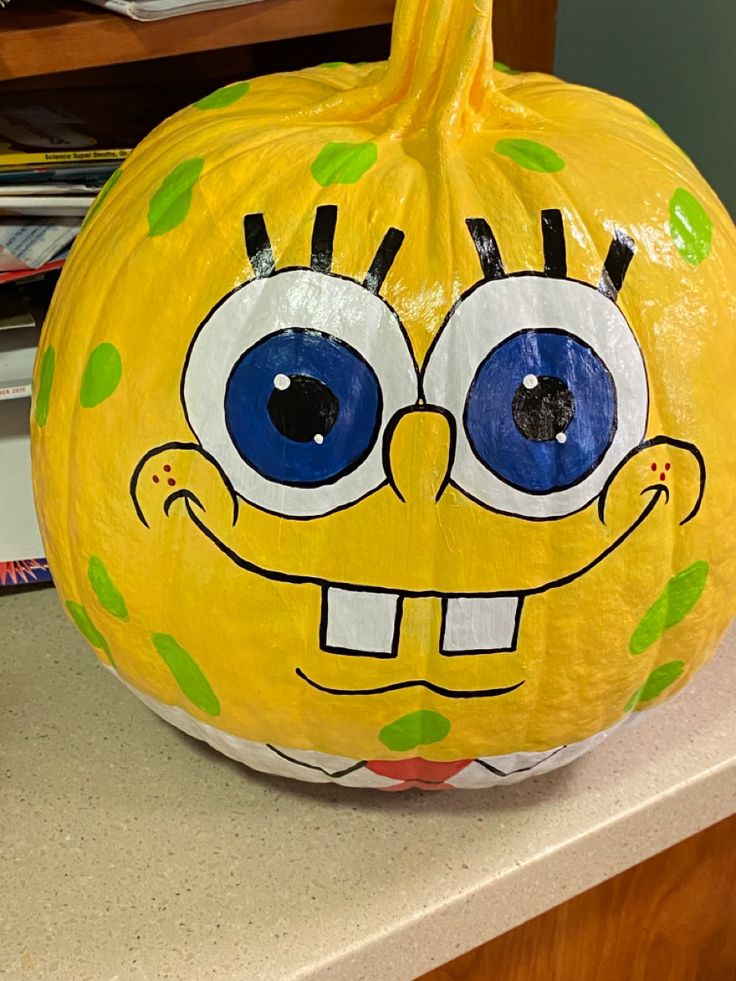 a yellow pumpkin decorated with an image of spongebob