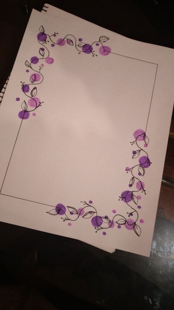 a piece of paper with purple flowers and vines on it, sitting on a table