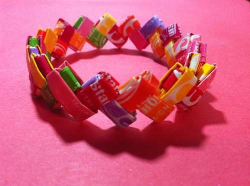 a close up of a candy bracelet on a pink surface