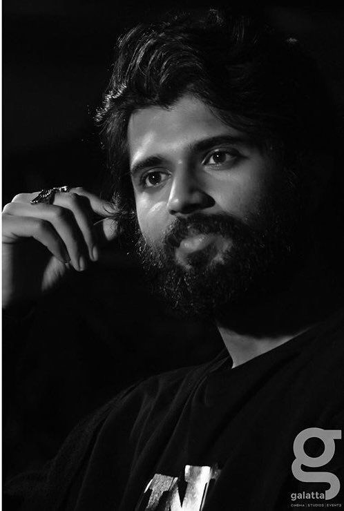 a black and white photo of a man with a beard wearing a t - shirt