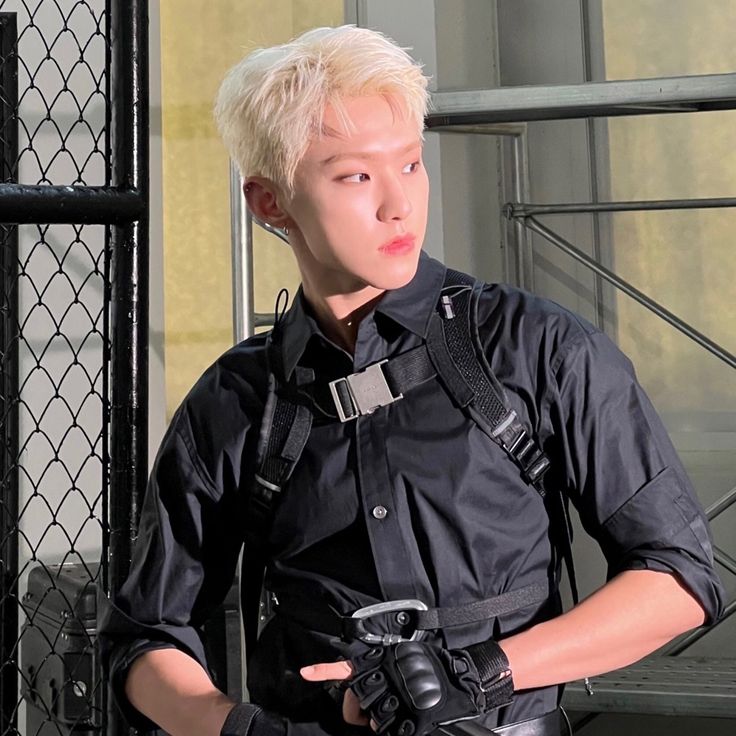 a man with white hair and black shirt holding a camera