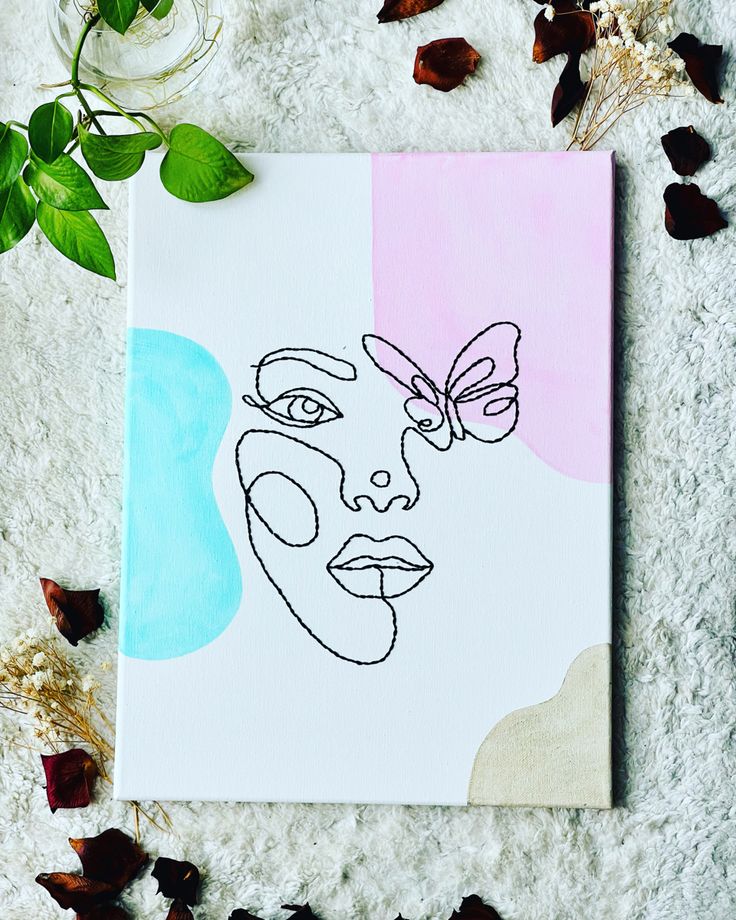 a drawing of a woman's face on a piece of paper surrounded by flowers