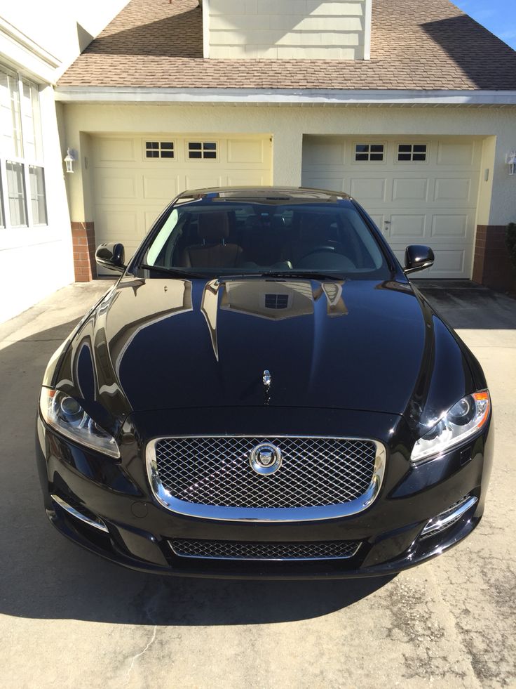 a black car parked in front of a house