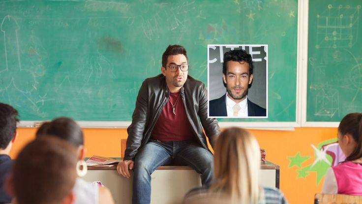 a man sitting on top of a box in front of a classroom full of children