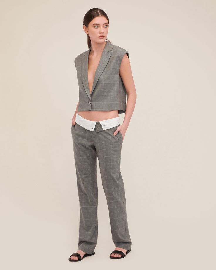 Cut in a smooth luxurious wool, the Dana is structured yet lightweight and features a daring deep V neckline. This vest effortlessly transitions from desk to dinner, ensuring you move through your day with confidence. Style the Dana with the Leo Foldover Waist Trouser for a hook up that embodies modern suiting with a touch of downtown edge. Easy fit Deep V neck Notch collar with traditional blazer details Single breasted, button closure Sleeveless Dropped armholes Light shoulder pad Fully lined Fitted V-neck Vest For Office, Chic Semi-formal Vest With Notch Lapel, Tailored Blazer With Vest For Office, Fitted V-neck Blazer For Office Wear, Tailored Notch Lapel Vest For Office, Fitted Blazer With Vest For Work, Tailored Vest Top For Business Casual, Modern Fitted Vest For Formal Occasions, Office Vest With Notch Lapel And Tailored Fit