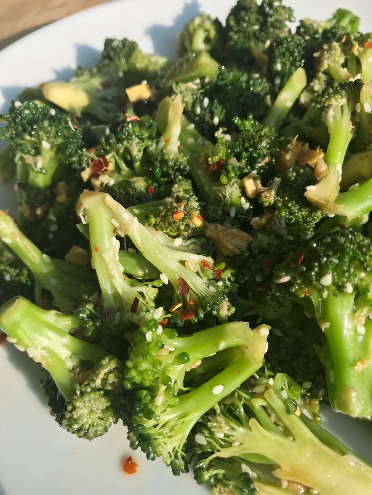 broccoli florets with sesame seeds and seasonings on a white plate