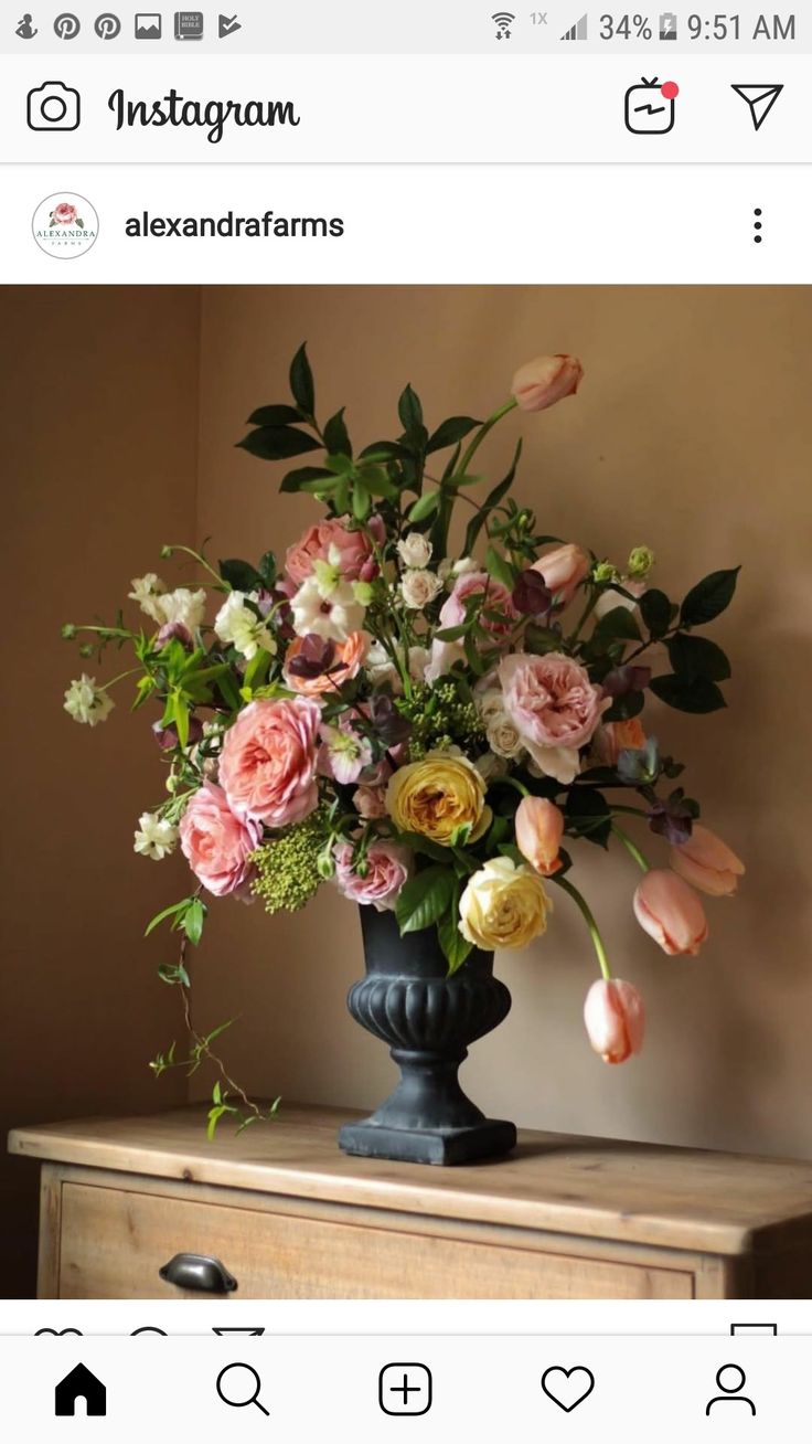 a vase filled with lots of flowers sitting on top of a dresser