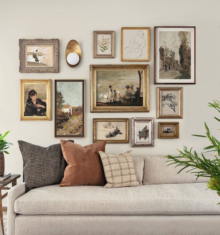 a living room filled with lots of pictures on the wall next to a white couch