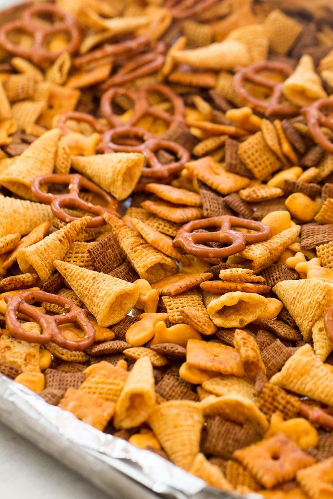 cheetos and pretzels are mixed together in a baking pan on the counter