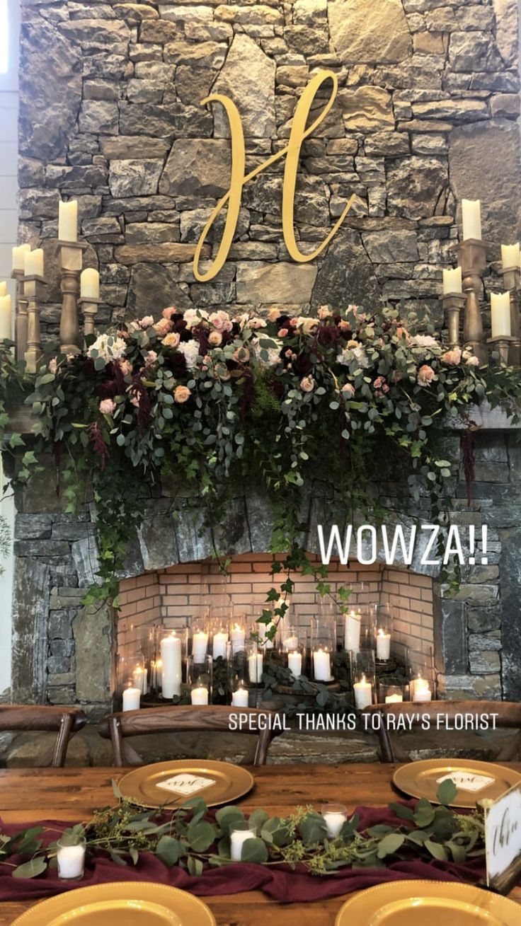 a fireplace decorated with flowers and candles for a wedding reception at wozzac