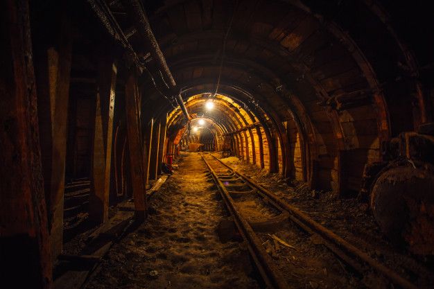 a train track going through a tunnel with light at the end