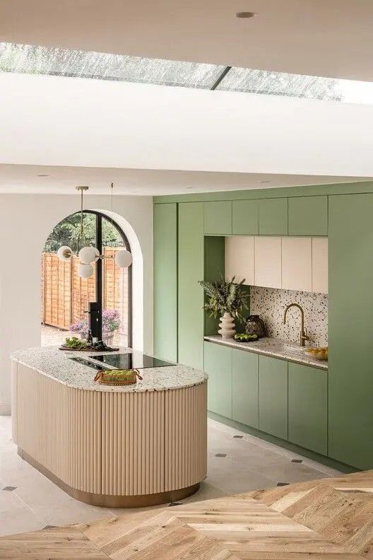 a kitchen with green cabinets and an island countertop in the middle of the room