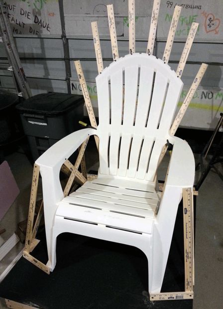 a white plastic chair sitting on top of a black floor