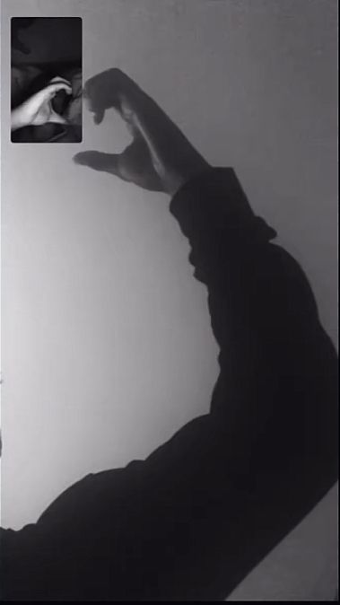 black and white photograph of a man holding his hand up in the air with one hand