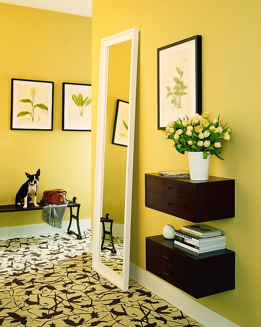 a room with yellow walls and pictures on the wall