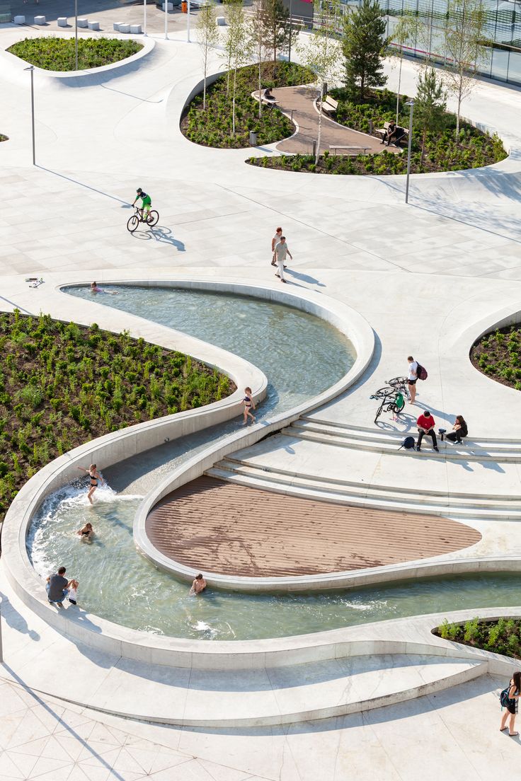 an aerial view of people walking, biking and playing in the water at a park