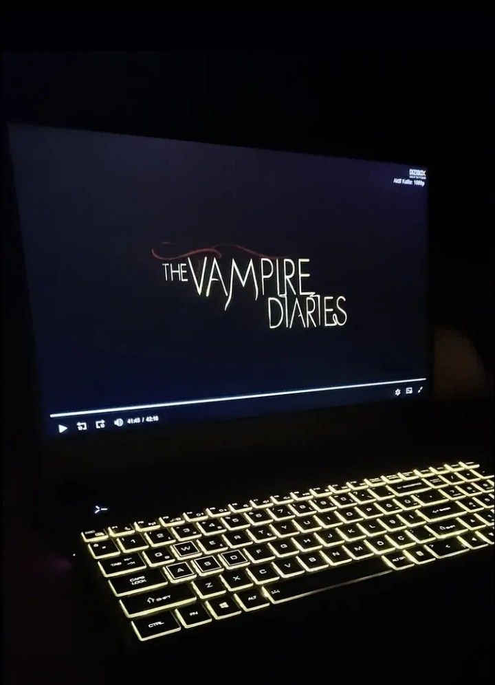 a laptop computer with the vampire diaries logo lit up on it's screen and keyboard