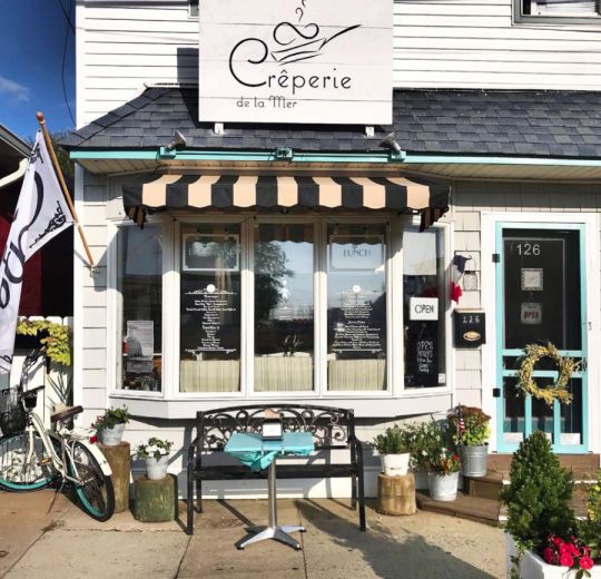 a bike is parked in front of a restaurant with an awning over the door