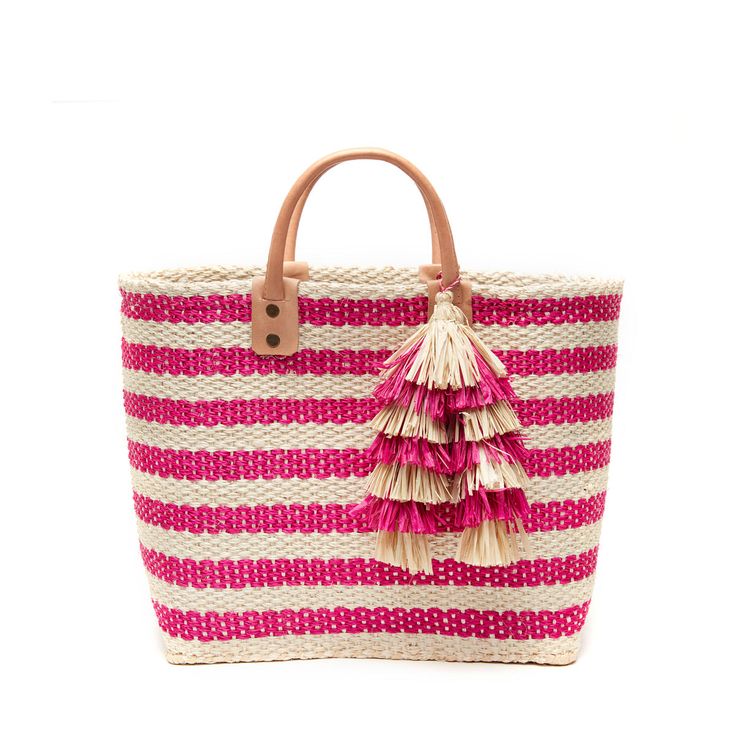 Summery stripes and festive tassels adorn our Sahara tote, which features leather carry handles and a sturdy structured silhouette.  Both stylish and practical, it's a great piece for the beach and beyond. 100% handwoven sisal and seagrass Unlined Inside pocket Raffia tassels Leather handles 16"W x 7.5"D x 11"H; 4.5" s Pink Sunflowers, Linen Bag, Crochet Bags, Traditional Crafts, 5 S, Leather Handles, Pink Stripes, Handmade Bags, Leather Handle