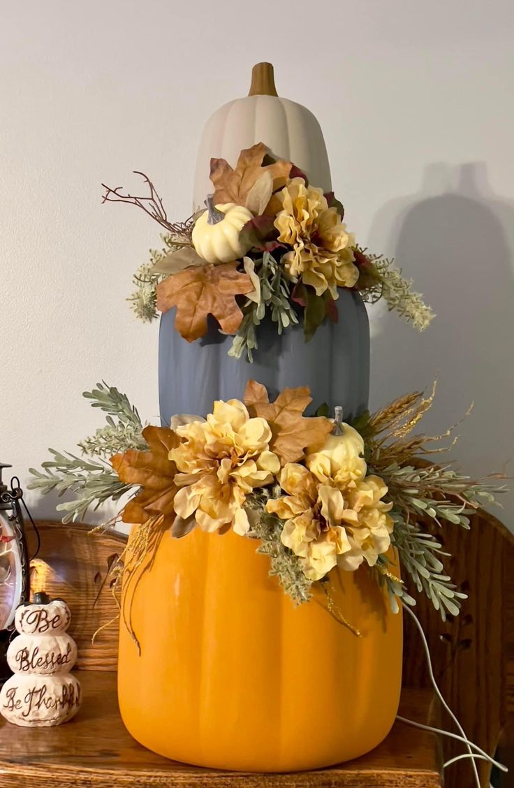 a three tiered pumpkin decorated with flowers