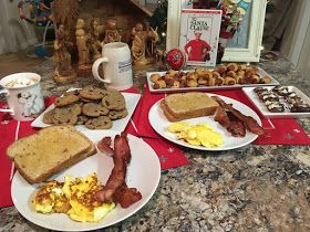 two white plates topped with breakfast foods on top of a counter next to a christmas tree