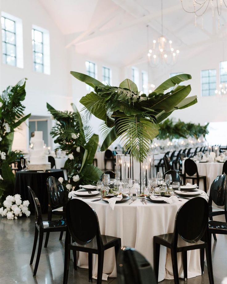 a table is set with black chairs and white tablescloths for an elegant wedding reception