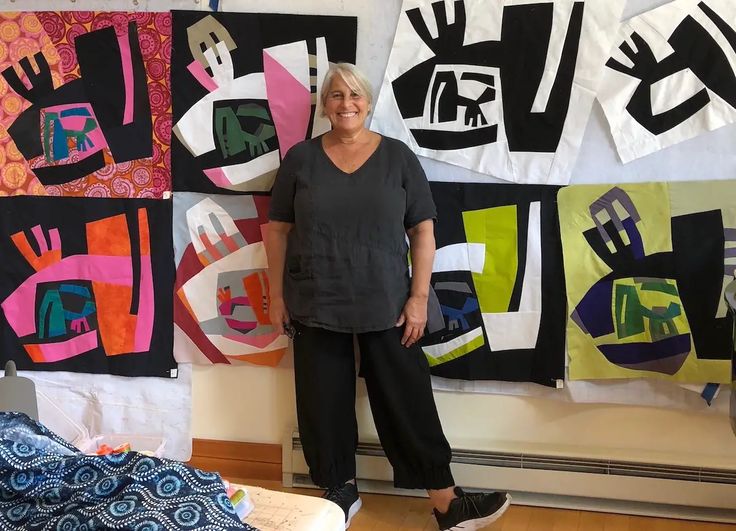 a woman standing in front of some colorful art