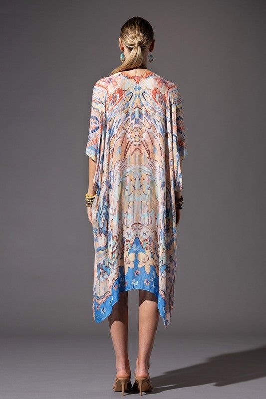 This kimono showcases a floral and Ikat print, with a mid-length style, side slits, and an open front design. Offering a lightweight and soft material, it is essential for summer and can be worn at the lake, beach, or pool as well as a wrap for a casual look. Relaxed, Oversized Fit 1/2 Length Kimono Sleeves Mid-length Side Slits Open Front Bohemian Style One size fits most Length: 38" Width: 40" Casual Open Front Kimono For Daywear, Blue Boho Print Kaftan For Summer, Spring Vacation Kaftan With Vibrant Print, Summer Blue Kaftan With Boho Print, Spring Kaftan With Kimono Sleeves For Daywear, Spring Daywear Kaftan With Kimono Sleeves, Vibrant Print Spring Vacation Kaftan, Spring Unlined Kaftan, Casual Summer Boho Print Kaftan