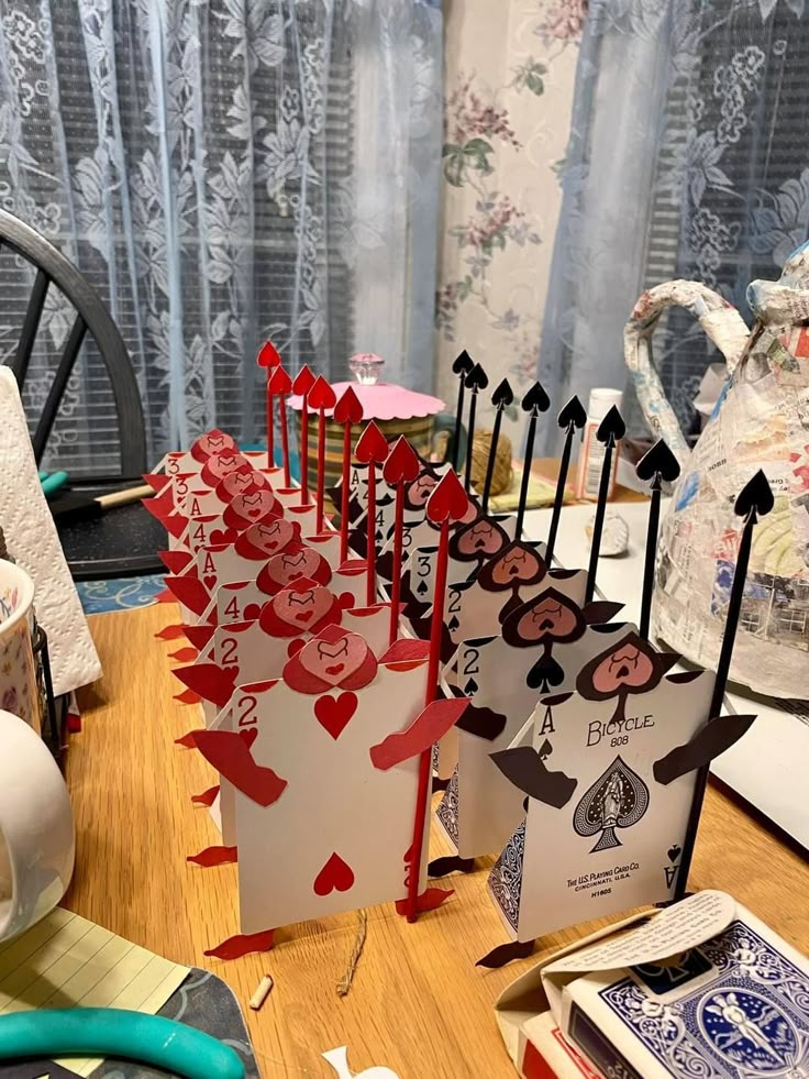 several cards are lined up on a table with scissors and other crafting supplies next to them