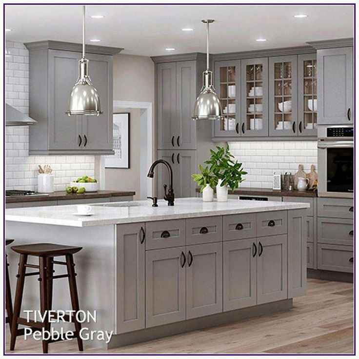 a large kitchen with gray cabinets and white counter tops