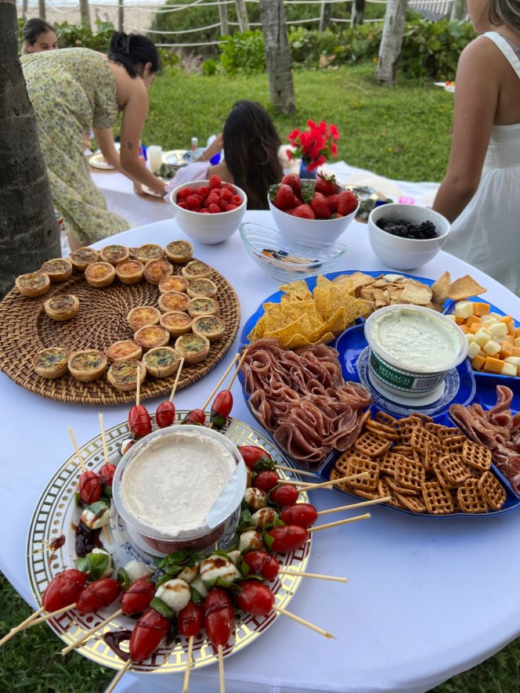 a table topped with lots of food on top of a blue and white table cloth