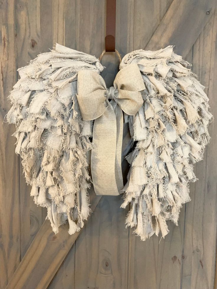 an angel wings wreath hanging on a door