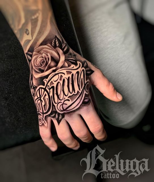 a person with a tattoo on their hand and the word proud written in cursive writing