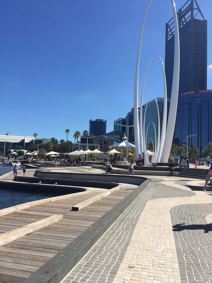 people are sitting on benches near the water