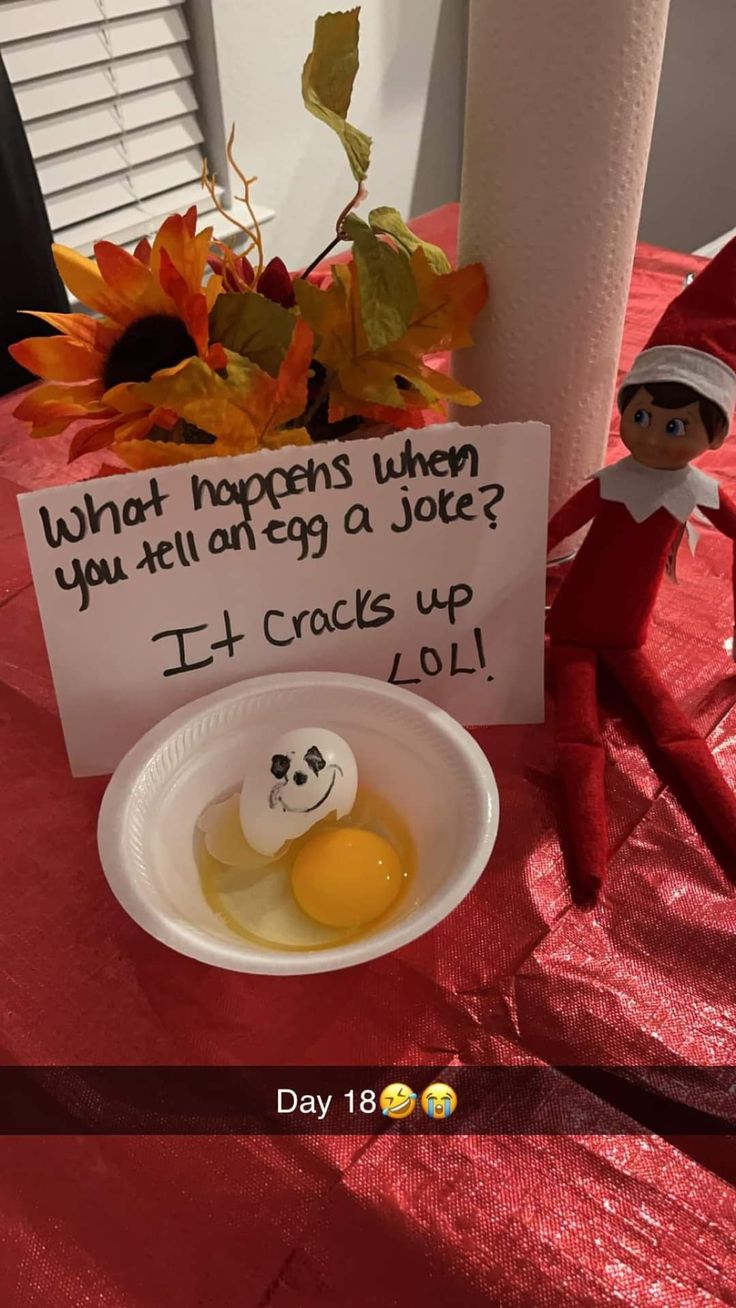 an elf is sitting in front of a sign that says, what happens when you tell egg joke? it cracks up