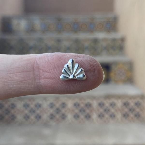 a person's finger with a tiny silver ring on top of it, in front of some steps