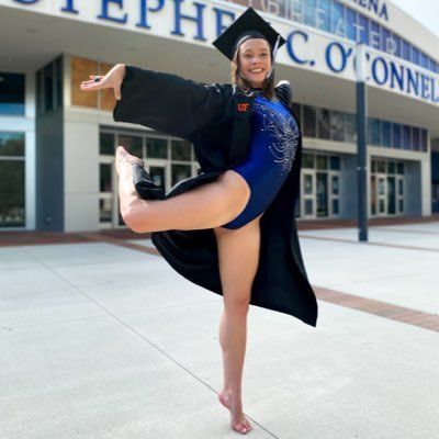 a woman in a cap and gown is doing a trick