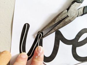 someone is using scissors to cut out letters